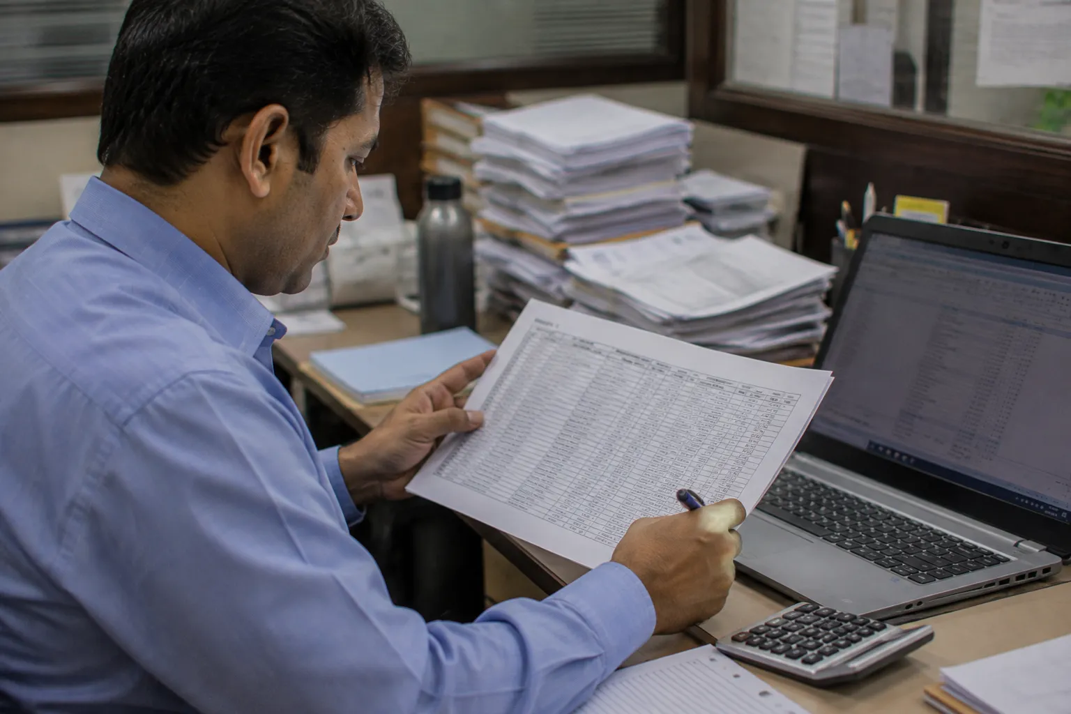 Accountant reviewing a printed asset depreciation register