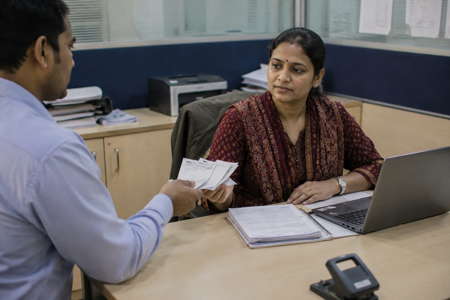 Employee handing an expense receipt to HR for a reimbursement claim