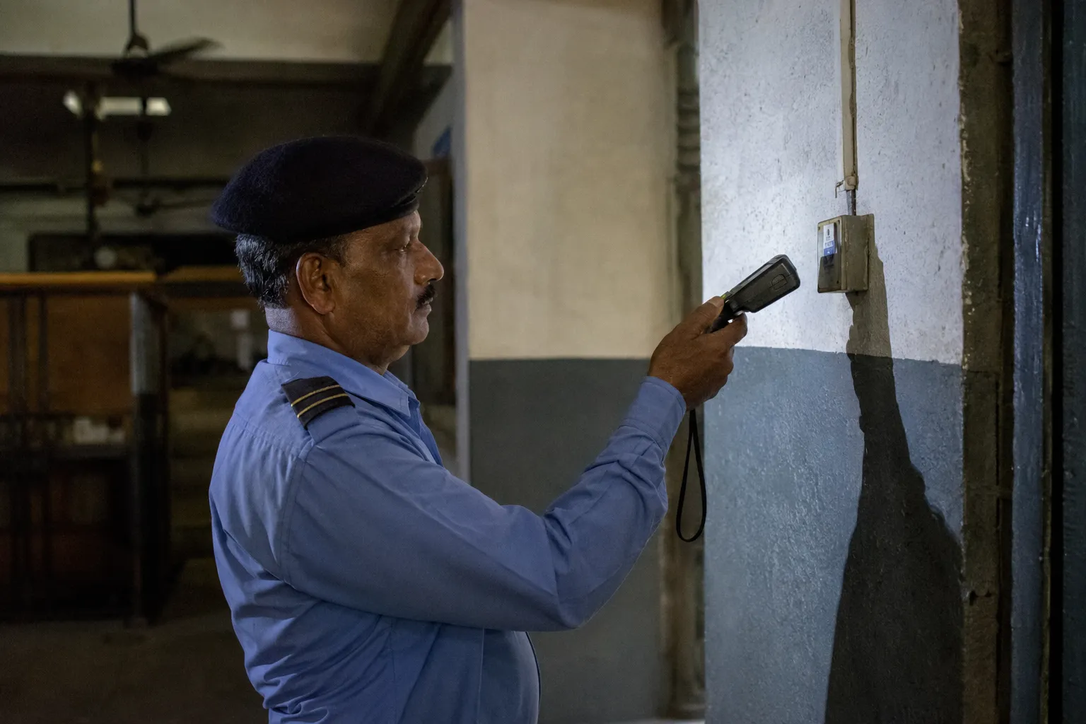 Security guard on a night patrol scanning an RFID checkpoint tag
